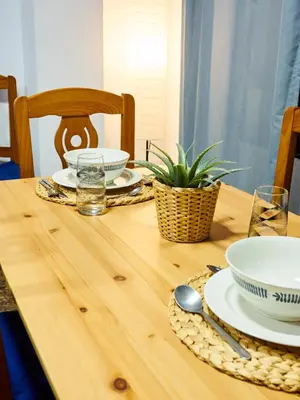 a wooden table with plates and bowls on it at COSTA AZUL in Puerto de Sagunto