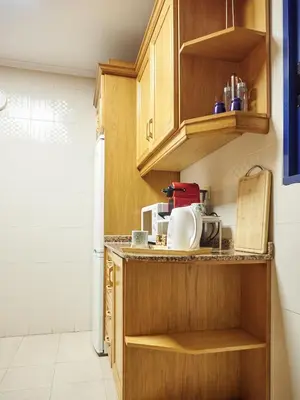 a kitchen with wooden cabinets and a white refrigerator at COSTA AZUL in Puerto de Sagunto
