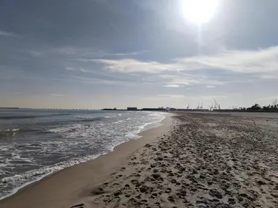 a beach with the sun shining on the water at COSTA AZUL in Puerto de Sagunto
