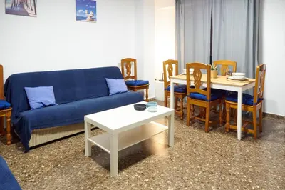 a living room with a couch and a table and chairs at COSTA AZUL in Puerto de Sagunto