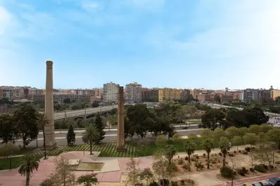 a view of a park with palm trees and buildings at SingularStays Alameda II in Valencia