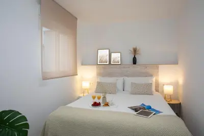 a bedroom with a bed with a tray of food on it at SingularStays Guillem Sorolla in Valencia