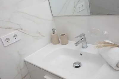 a white bathroom with a sink and a mirror at SingularStays Guillem Sorolla in Valencia