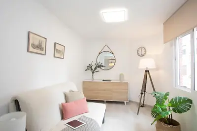 a white living room with a white couch and a mirror at SingularStays Guillem Sorolla in Valencia