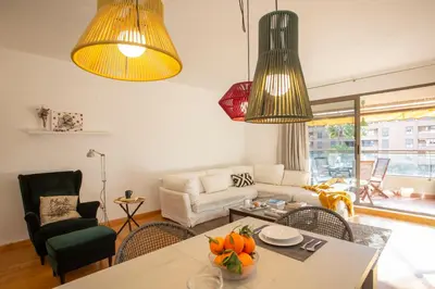 a living room with a table and two lights at SingularStays Palacio de Congresos in Valencia