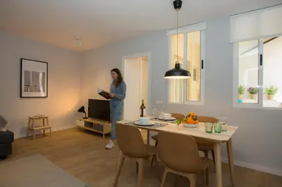 a woman standing in a living room with a table at SingularStays Quevedo II in Valencia