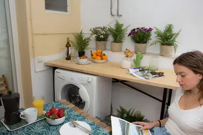 a woman sitting at a table reading a magazine at SingularStays Quevedo II in Valencia