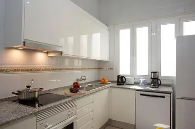 a kitchen with white cabinets and a sink at SingularStays Salvador IV in Valencia