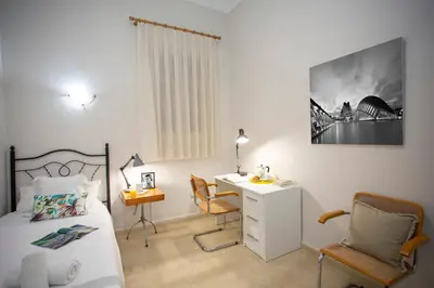 a bedroom with a bed and a desk and a bed and a chair at SingularStays Salvador IV in Valencia