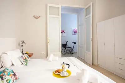 a white bedroom with a white bed with a plate of food on it at SingularStays Salvador IV in Valencia