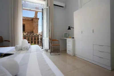a bedroom with a bed and a desk and a window at SingularStays Salvador IV in Valencia