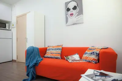 an orange couch in a living room with a picture at SingularStays Salvador II in Valencia