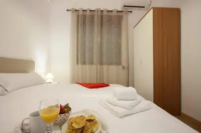 a bed with a plate of food and a glass of orange juice at SingularStays SEU V in Valencia