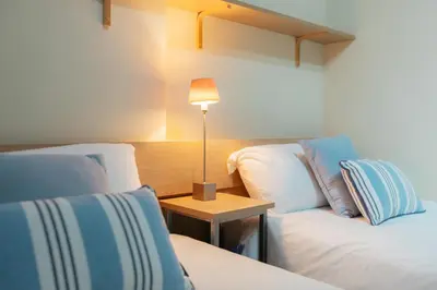 a room with two beds and a table with a lamp at RESORT BEACH VALENCIA in Valencia