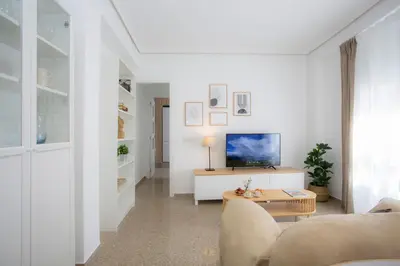 a white living room with a couch and a tv at SingularStays Campanar in Valencia