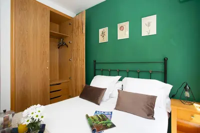 a bedroom with green walls and a bed with white pillows at SingularStays Clero in Valencia