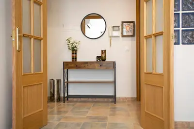 a hallway with two wooden doors and a table with a mirror at SingularStays Clero in Valencia