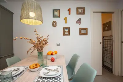 a dining room table with a vase of oranges on it at SingularStays Oceanografico II in Valencia