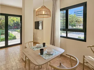 a dining room with a table and chairs and windows at Apartamentos Las Ciencias Studio X in Valencia