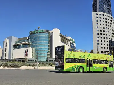 a yellow and green bus parked in front of buildings at Apartamentos Las Ciencias Studio X in Valencia
