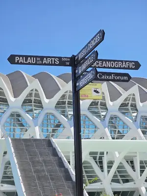 a pole with street signs in front of a building at Apartamentos Las Ciencias Studio T in Valencia