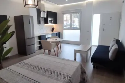a room with a bed and a kitchen with a table at Estudio diseño cerca Ciudad Ciencias VT-55211-V in Valencia