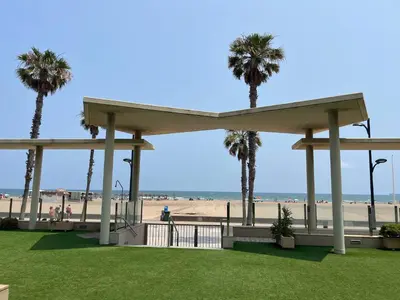 a gazebo at the beach with palm trees at Valencia Beach Apartment - La Patacona in Valencia