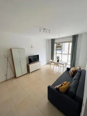 a living room with a black couch and a table at Valencia Beach Apartment - La Patacona in Valencia