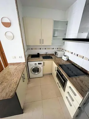 a small kitchen with white cabinets and a stove at Valencia Beach Apartment - La Patacona in Valencia
