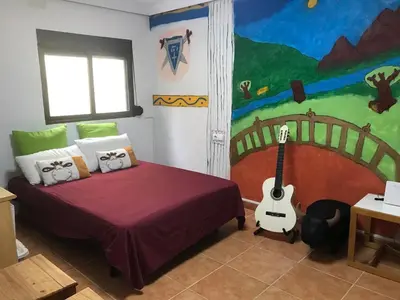 a bedroom with a bed with a guitar in it at Alto Oasis in Siete Aguas