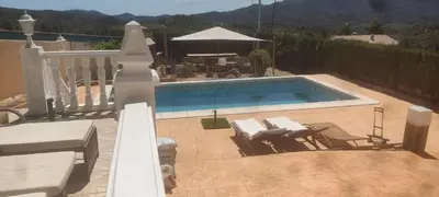 a swimming pool with two chairs and a table at Alto Oasis in Siete Aguas