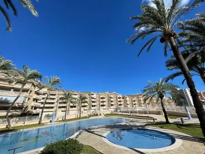 a large building with palm trees and a swimming pool at Almar Collection Cullera Bahía Park in Cullera