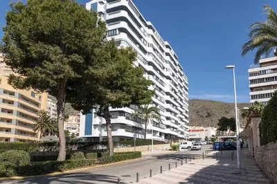 a city street with a large white apartment building at LAS VEGAS, esc-1, 7-14 in Cullera