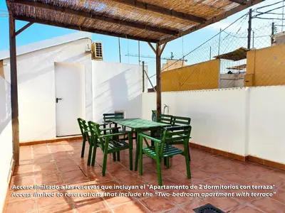 a patio with a green table and chairs at Flats Friends Torres Quart in Valencia