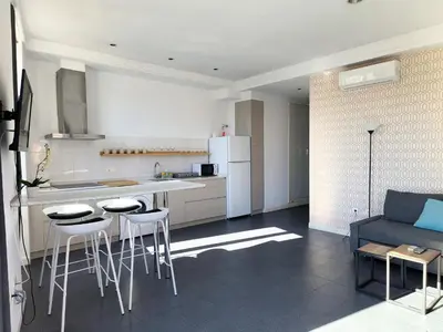 a kitchen with a counter and stools in a room at Flats Friends Torres Quart in Valencia