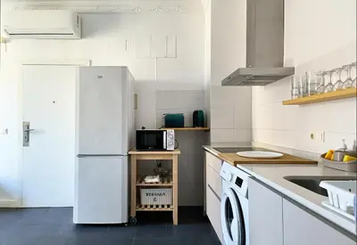 a white kitchen with a refrigerator and a microwave at Flats Friends Torres Quart in Valencia