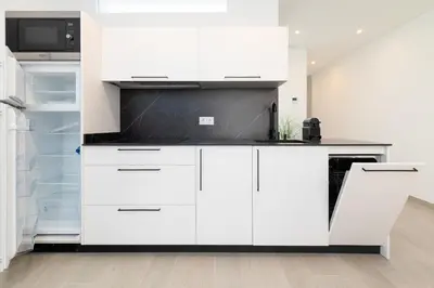 a kitchen with white cabinets and a refrigerator at Ca Celieta Beach II in Valencia