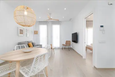 a white living room with a table and a couch at Ca Celieta Beach II in Valencia