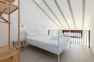 a bedroom with a white bed and a balcony at Ca Celieta Beach III in Valencia