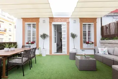 a patio with green grass and a table and chairs at Family Century House with terrace and parking in Valencia