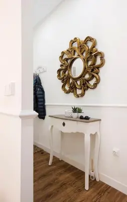 a mirror on a wall next to a table at Family Century House with terrace and parking in Valencia