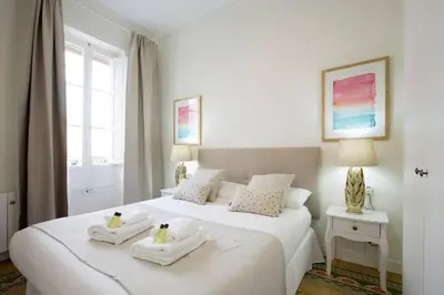 a white bedroom with two beds with towels on them at Family Century House with terrace and parking in Valencia