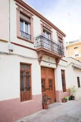 a white and pink building with a balcony at Family Century House with terrace and parking in Valencia