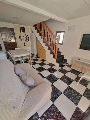 a living room with a couch and a checkered floor at Casa Pagan in Cullera
