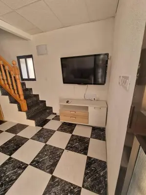 a room with a television and a checkered floor at Casa Pagan in Cullera