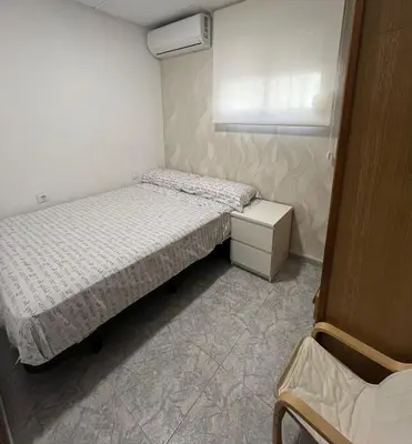 a small bedroom with two beds and a window at Casa Pagan in Cullera