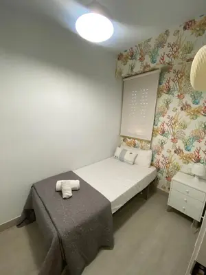 a small bedroom with a bed and a wall at Travel Habitat Playa del Puig in Valencia