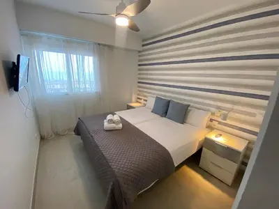 a small bedroom with a bed and a window at Travel Habitat Playa del Puig in Valencia