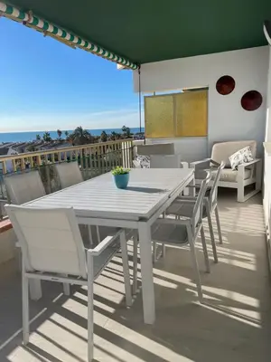a white dining table and chairs on a balcony at Travel Habitat Playa del Puig in Valencia