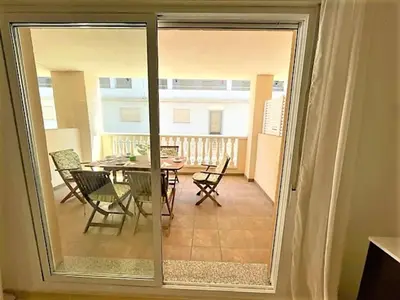 a sliding glass door leading to a patio with a table and chairs at Apartment Grao de Moncofar Ref 041 in Moncófar